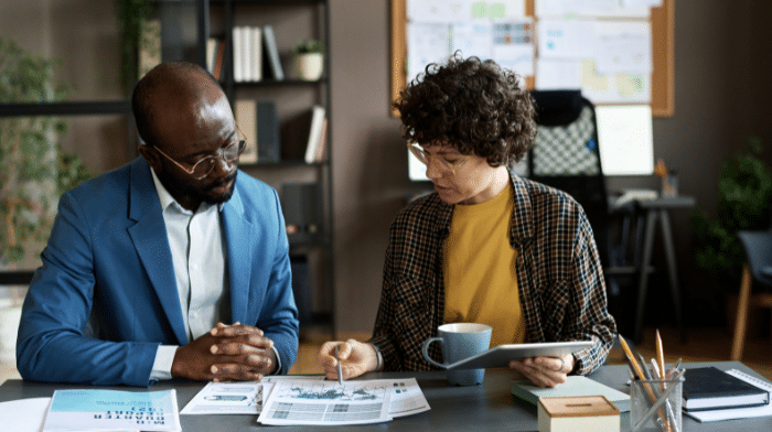 Man and woman in a business meeting looking at a chart